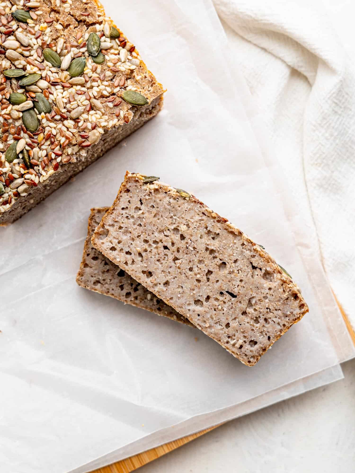 Two slices of fermented buckwheat bread on parchment paper.