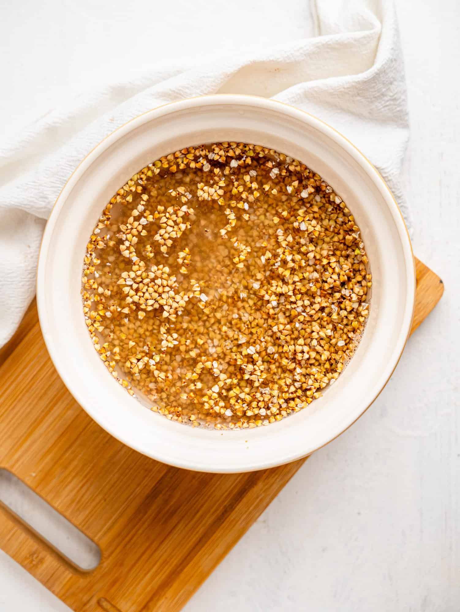 Buckwheat groats and water in a mixing bowl.