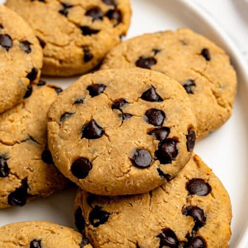 Homemade chocolate chip protein cookies arranged on a white plate.