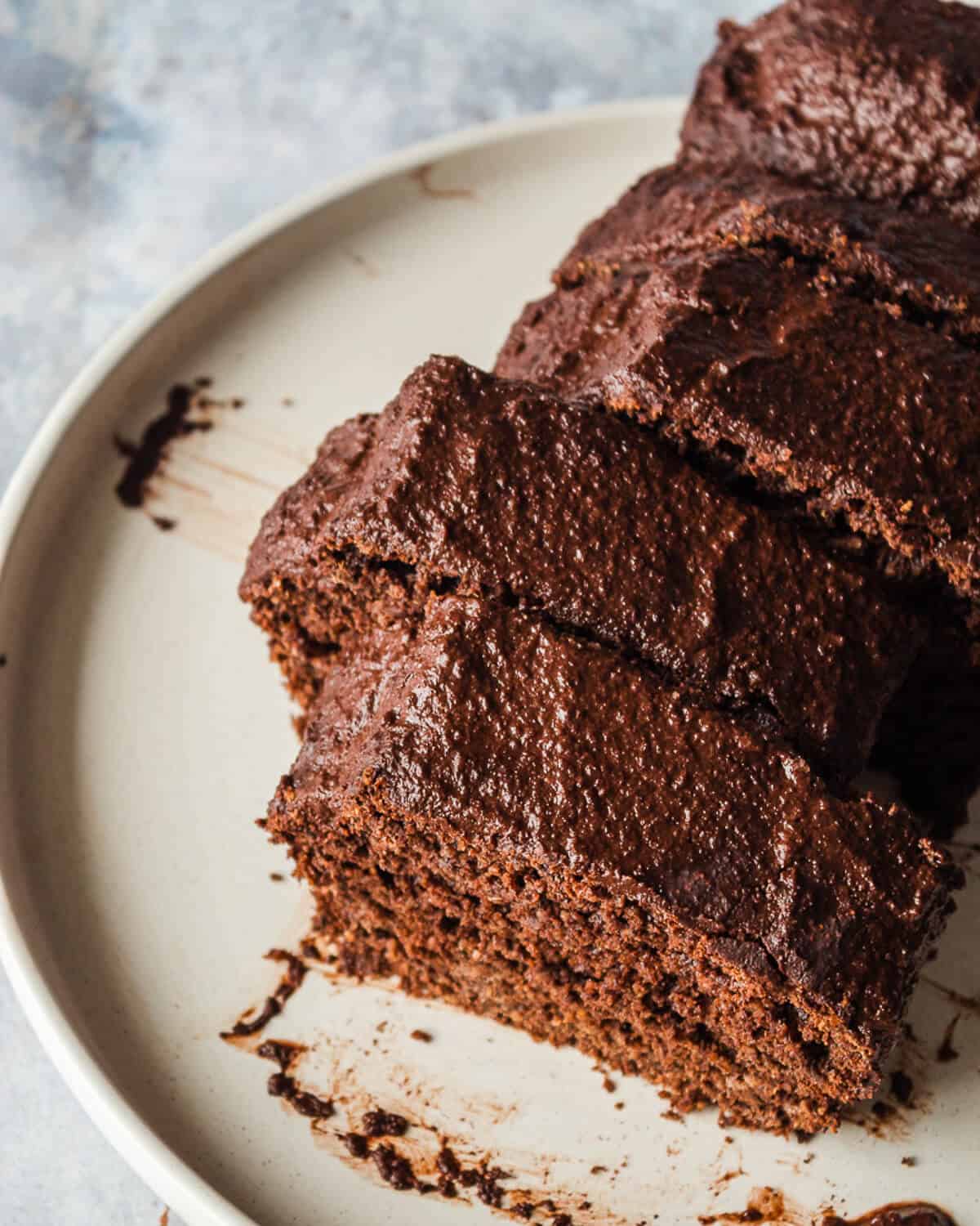 A sliced chocolate loaf cake on a white plate