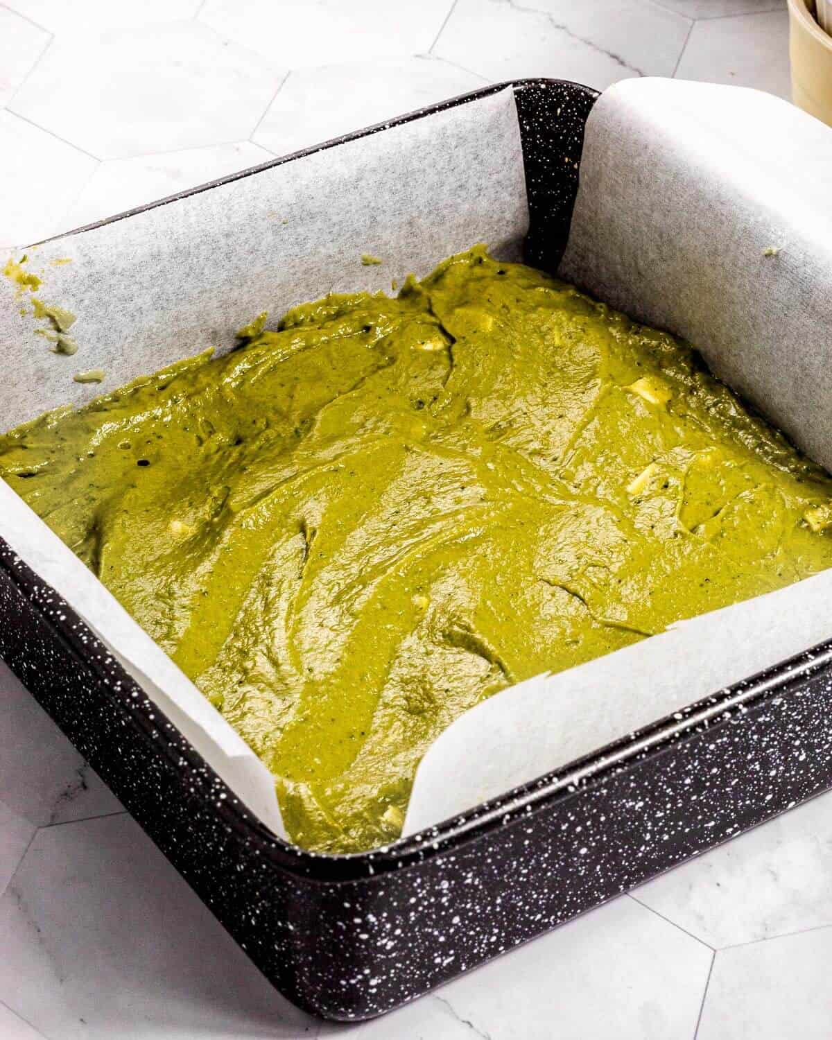 Matcha brownie batter in a baking tin before baking.