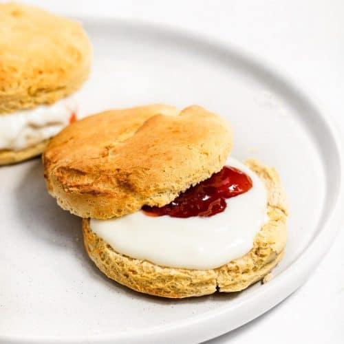 Two scones with yoghurt and strawberry jam.