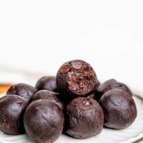 Easy and Healthy Brownie Batter Bites on a plate. One is bitten in half.