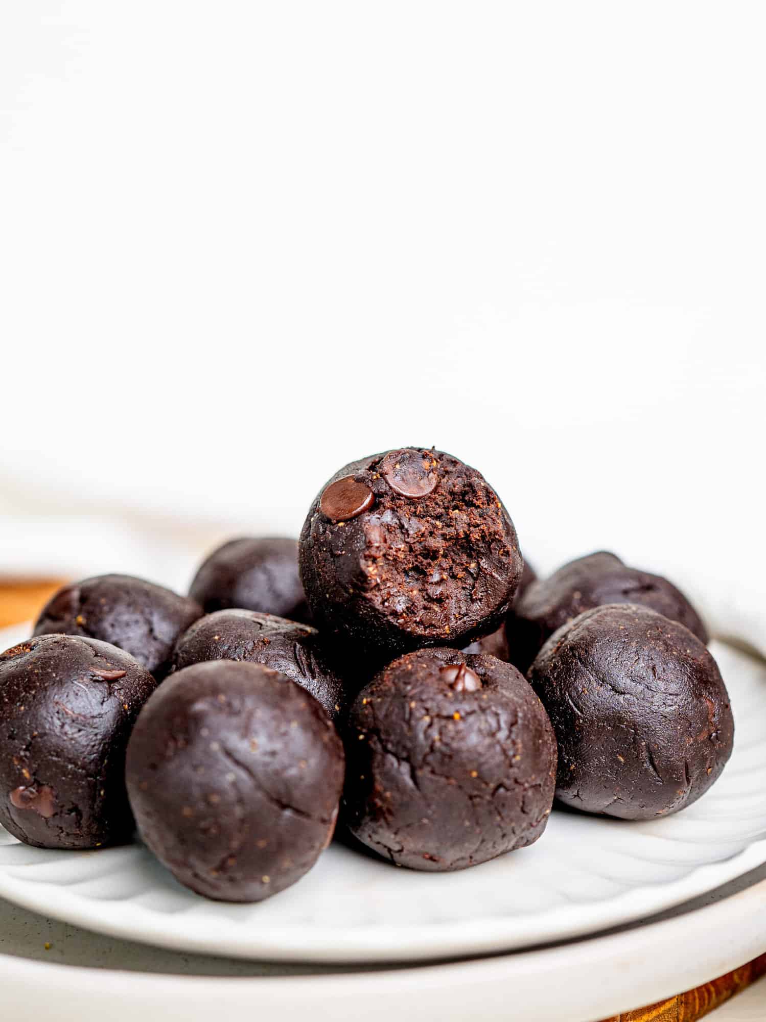 Easy and Healthy Brownie Batter Bites on a plate. One is bitten in half.