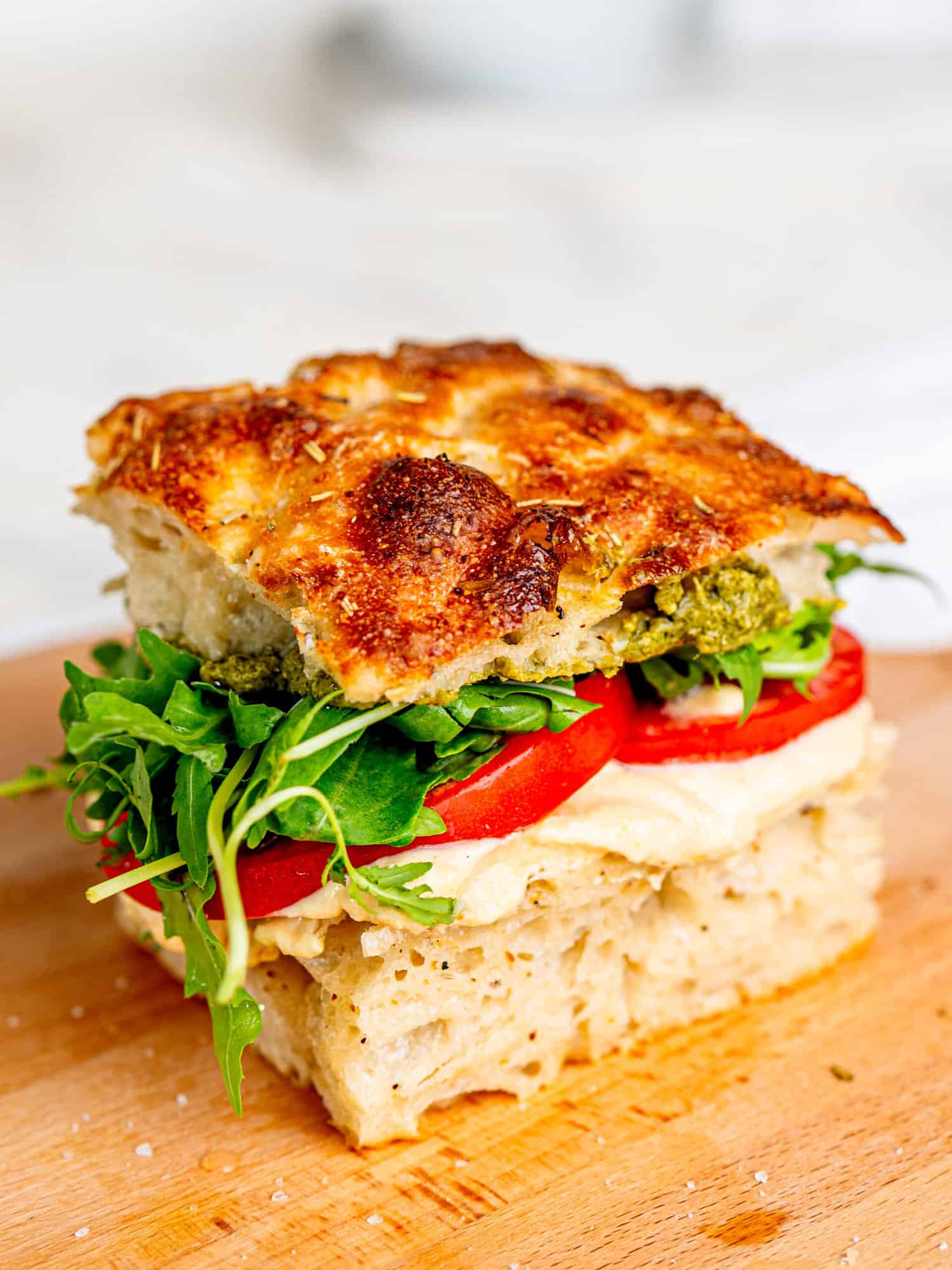 Focaccia sandwich with cottage cheese hummus, tomatoes, rocket and pesto.