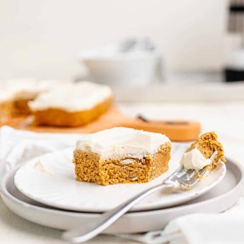 A no-bake carrot cake bar on a plate, a corner has been removed.