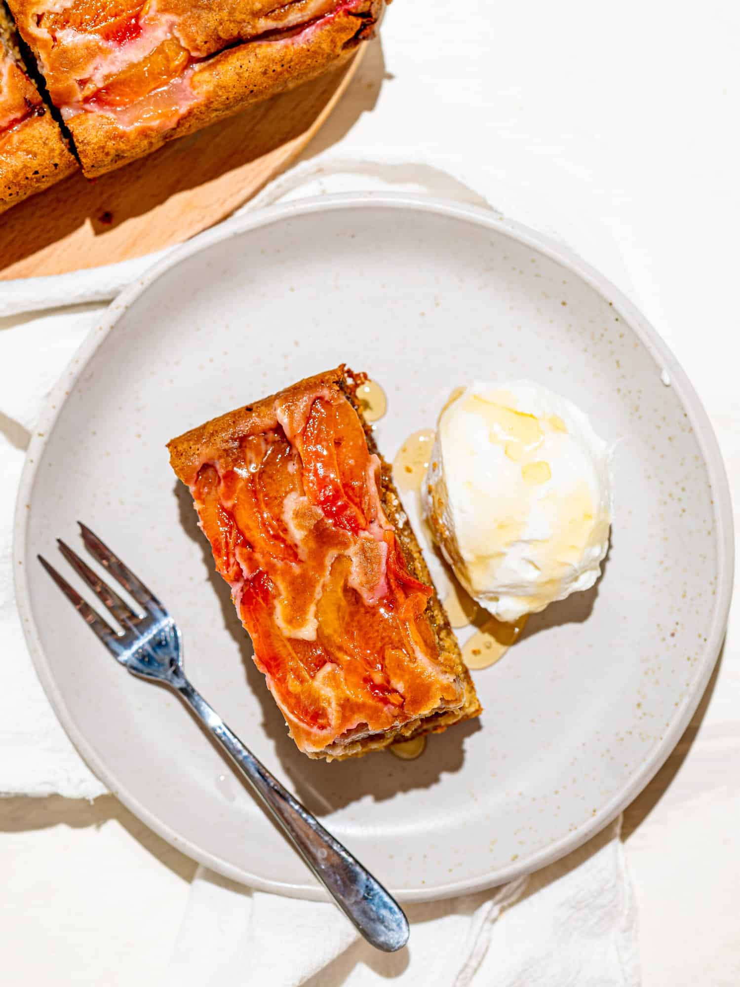 A slice of honey oat cake with plums and Greek Yoghurt.