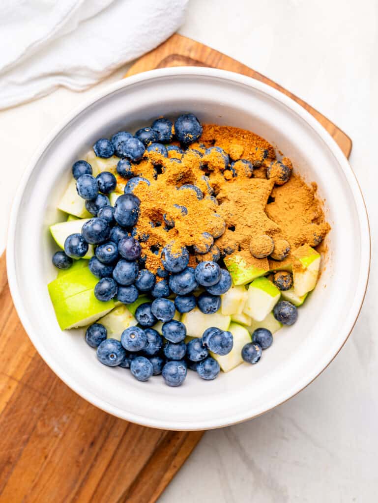 Ingredients for blueberry apple crumble filling in a bowl.