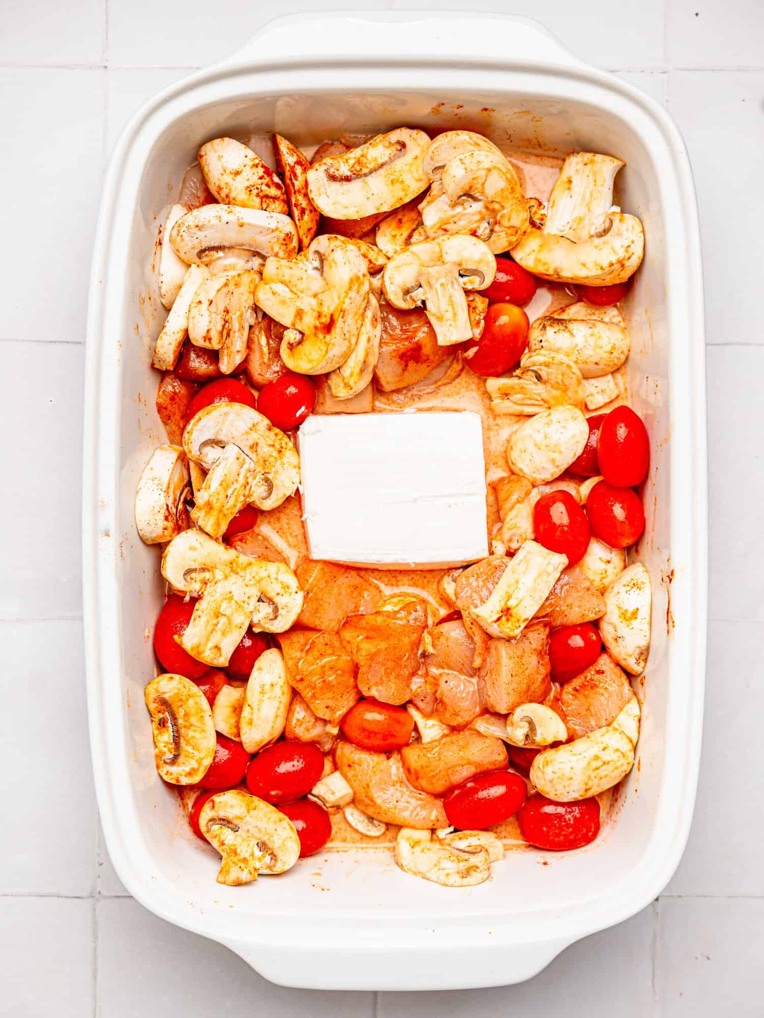 Ingredients for feta chicken bake in casserole dish ready to be baked.