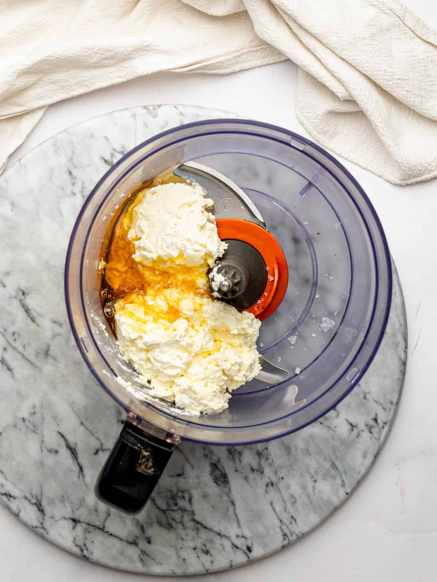 Cottage cheese and honey in a food processor before blending.