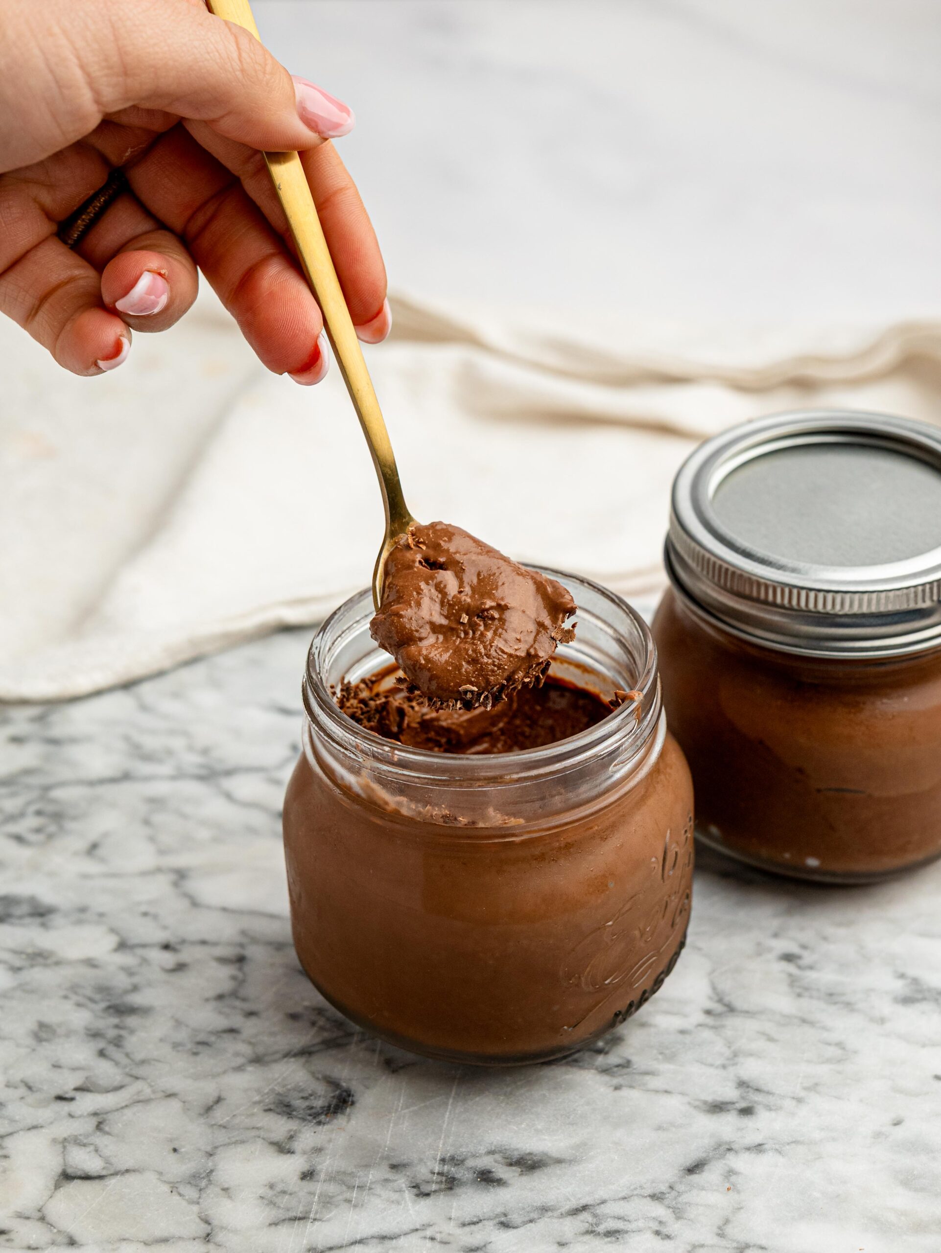 Spoonful of Healthy Cottage Cheese Chocolate Mousse lifted from a glass jar.