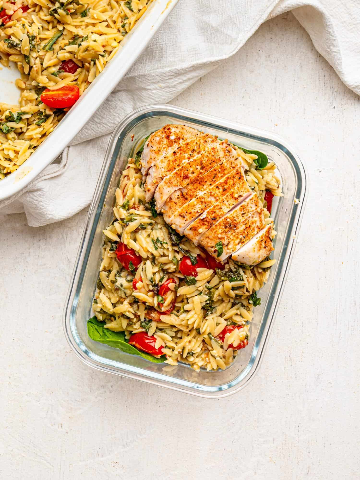 Chicken and Orzo Bake in a glass meal-prep container.