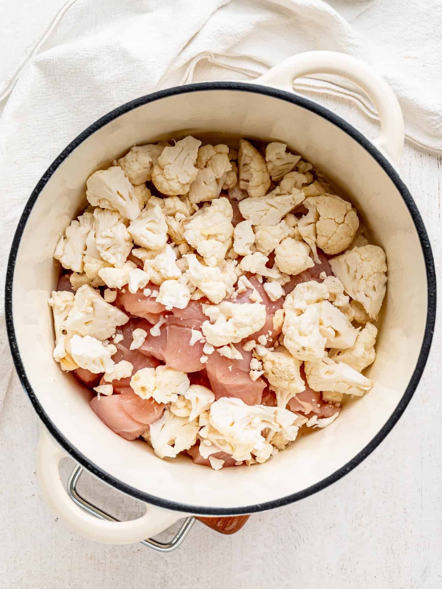 Chicken and cauliflower in a white pot.