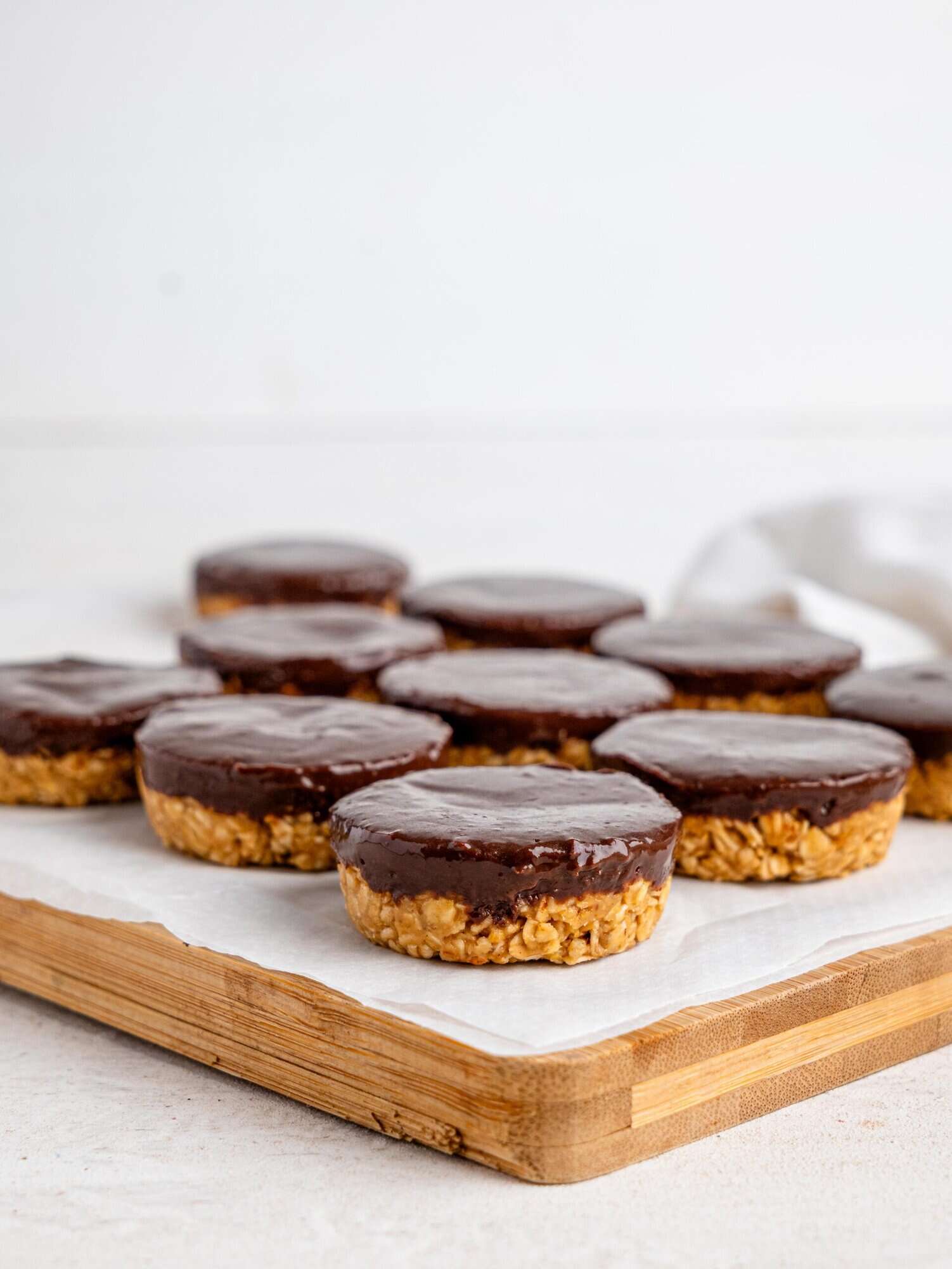 Chocolate peanut butter oatmeal cups on a wooden chopping board.