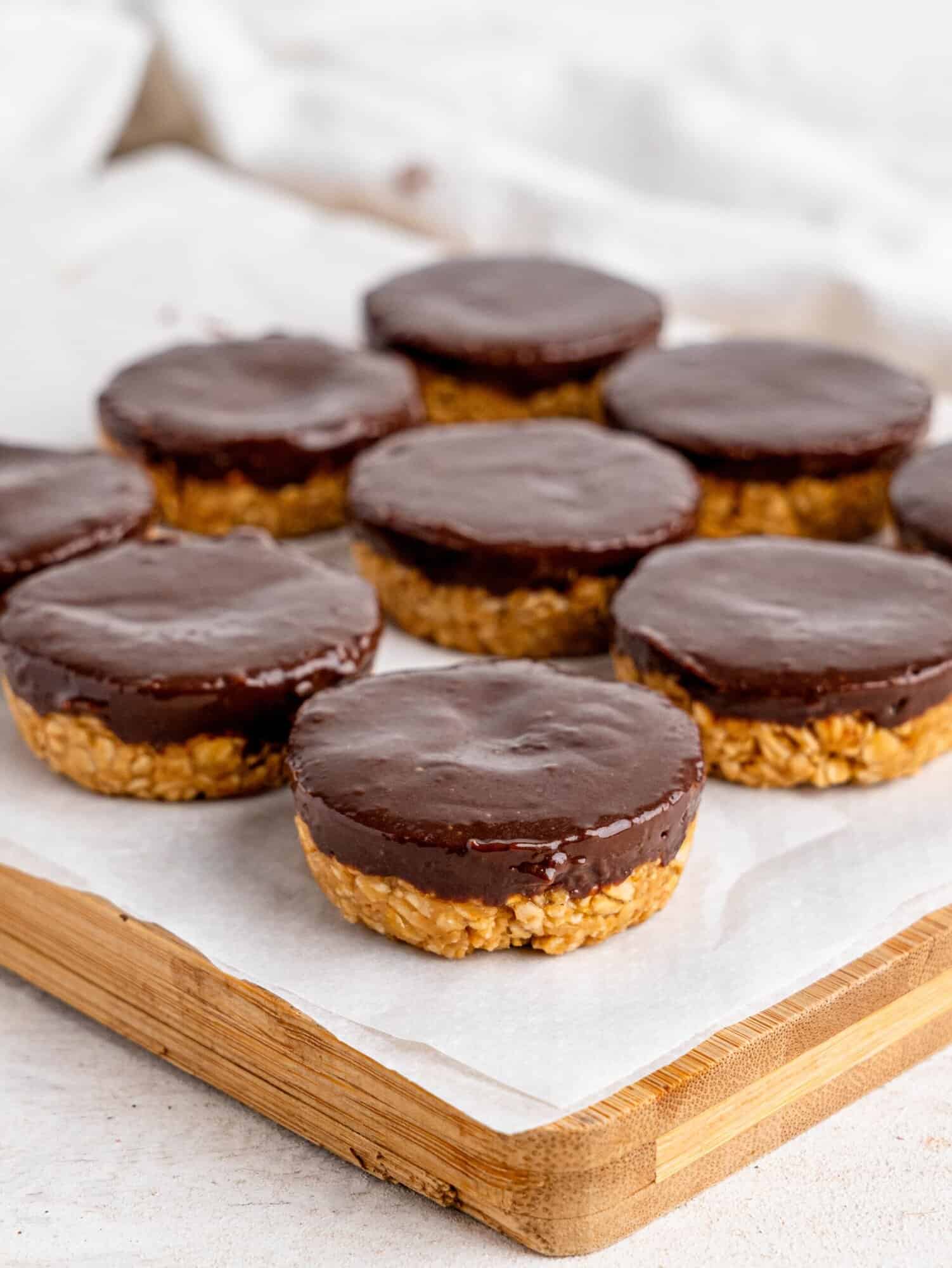 Chocolate peanut butter oatmeal cups on a wooden chopping board.