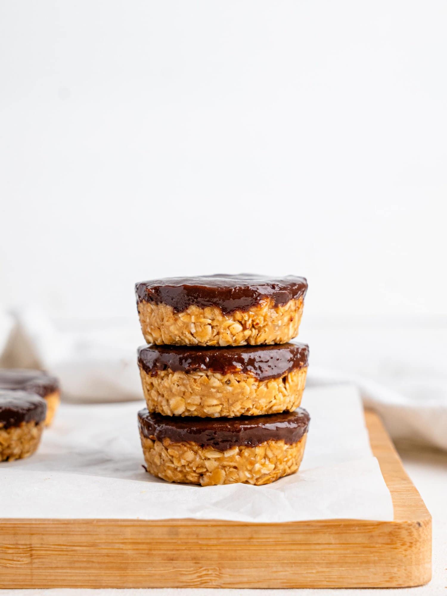 Three chocolate peanut butter oatmeal cups stacked on top of each other.