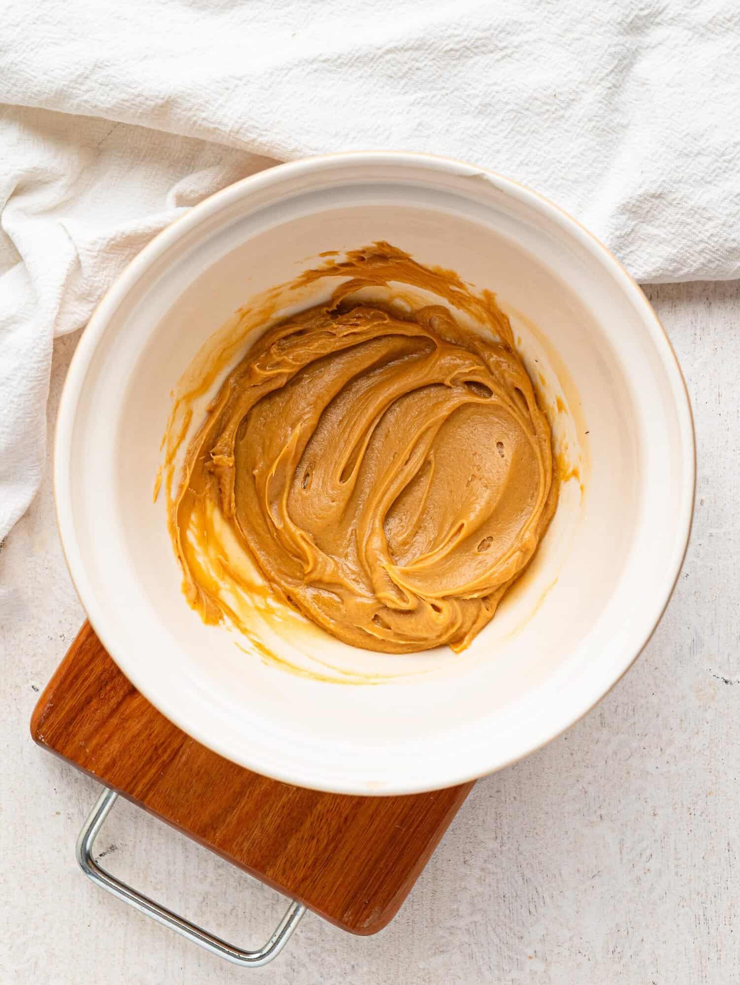 Peanut butter and honey combined in a mixing bowl.