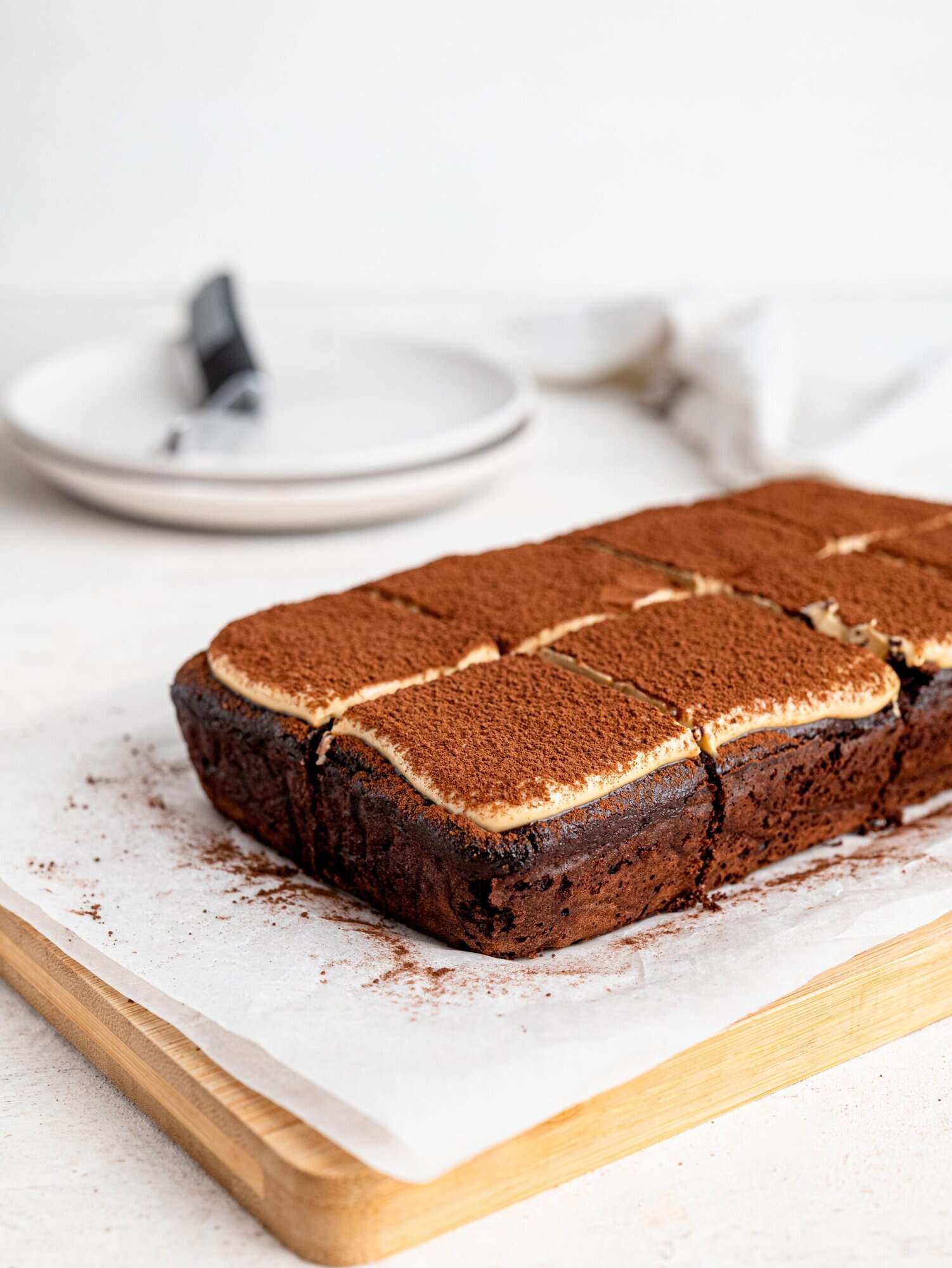 Tiramisu brownies on a wooden chopping board.
