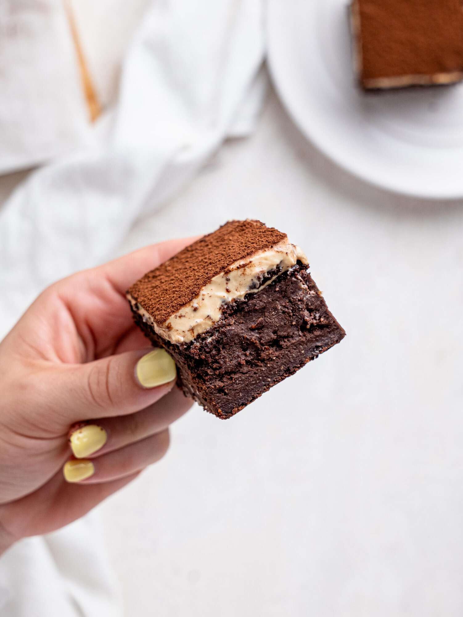 A hand holdng a tiramisu brownie.