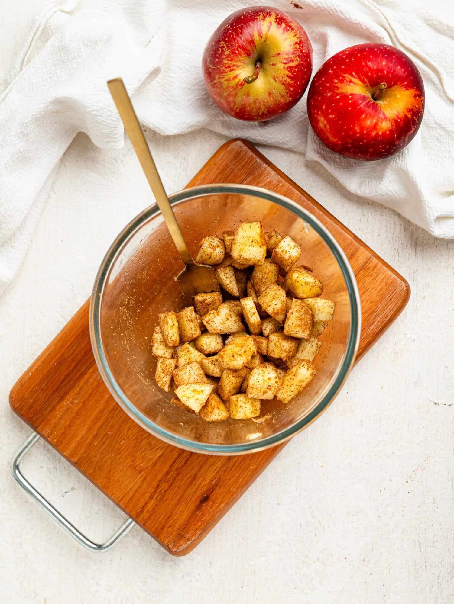 Chopped apple, coconut sugar and cinnamon in a small bowl.
