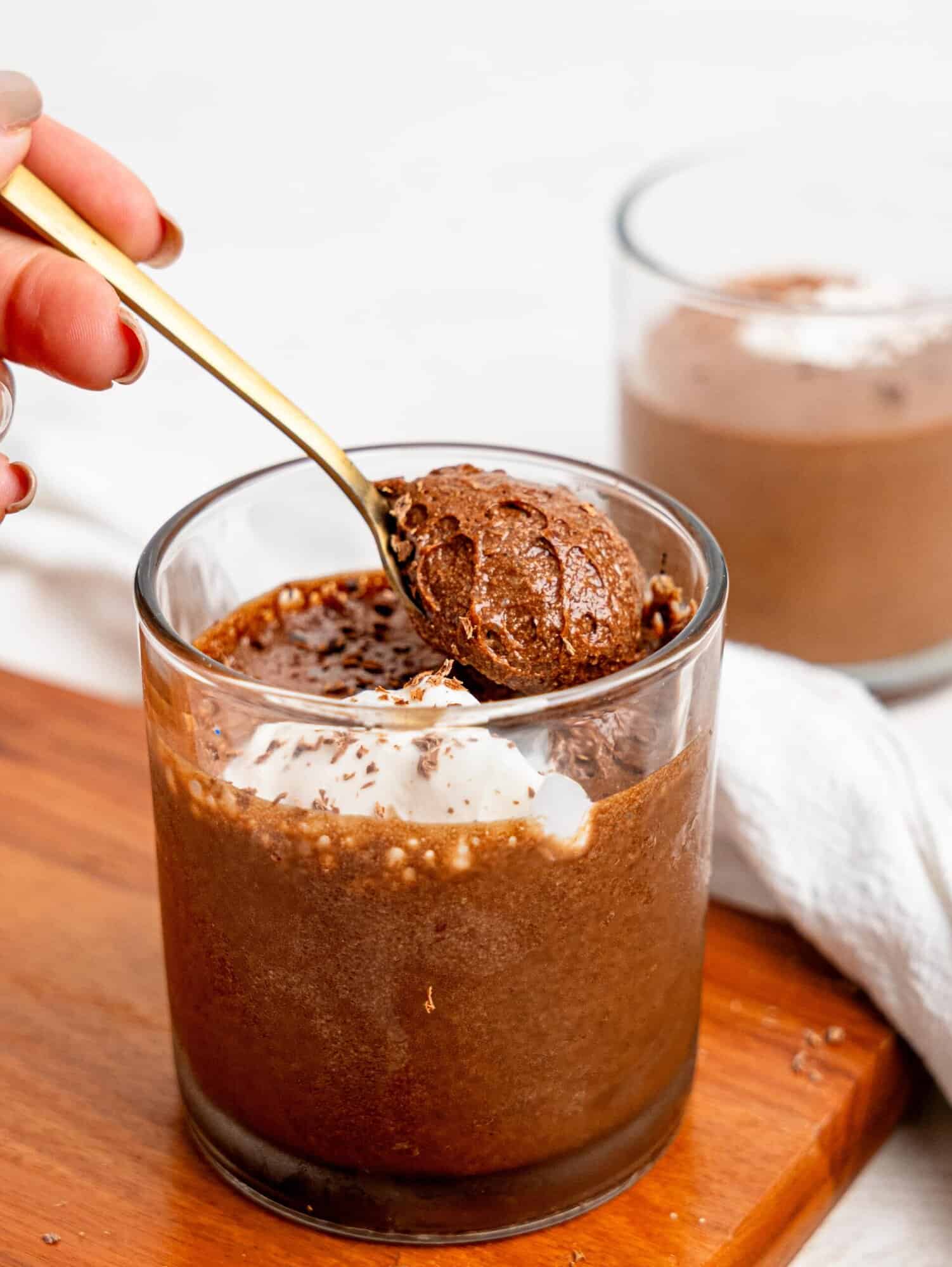 Spooning Chocolate Protein Mousse in a glass cup.