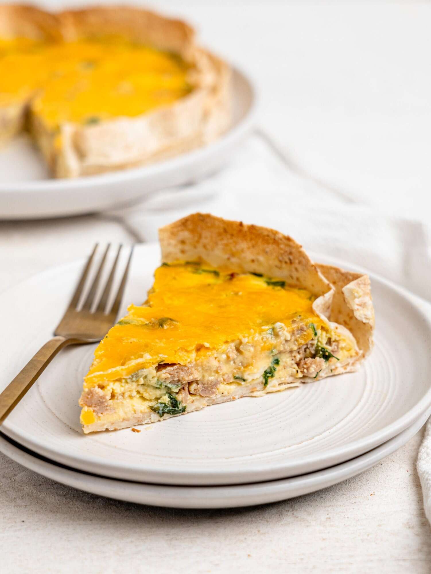A slice of tortilla quiche on a white plate.