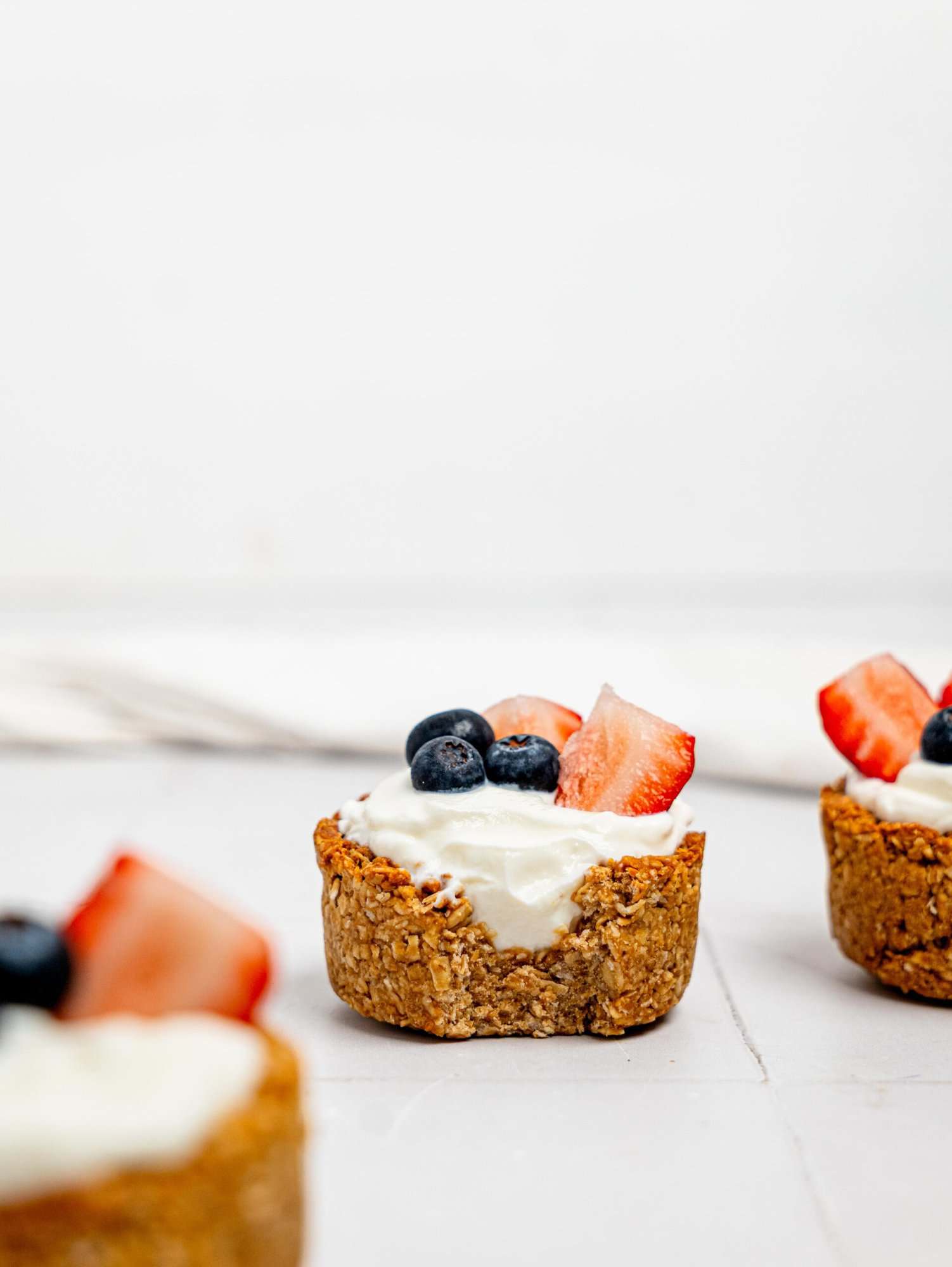 A half eaten granola cup filled with yoghurt and berries.