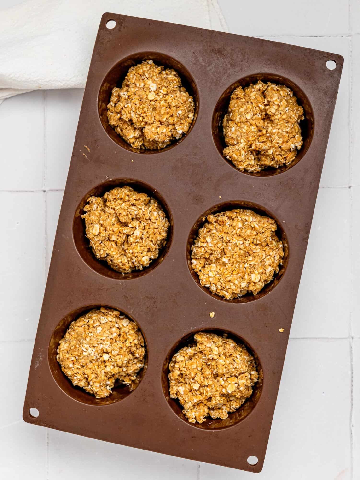 Granola cup mixture in a silicone muffin tray.