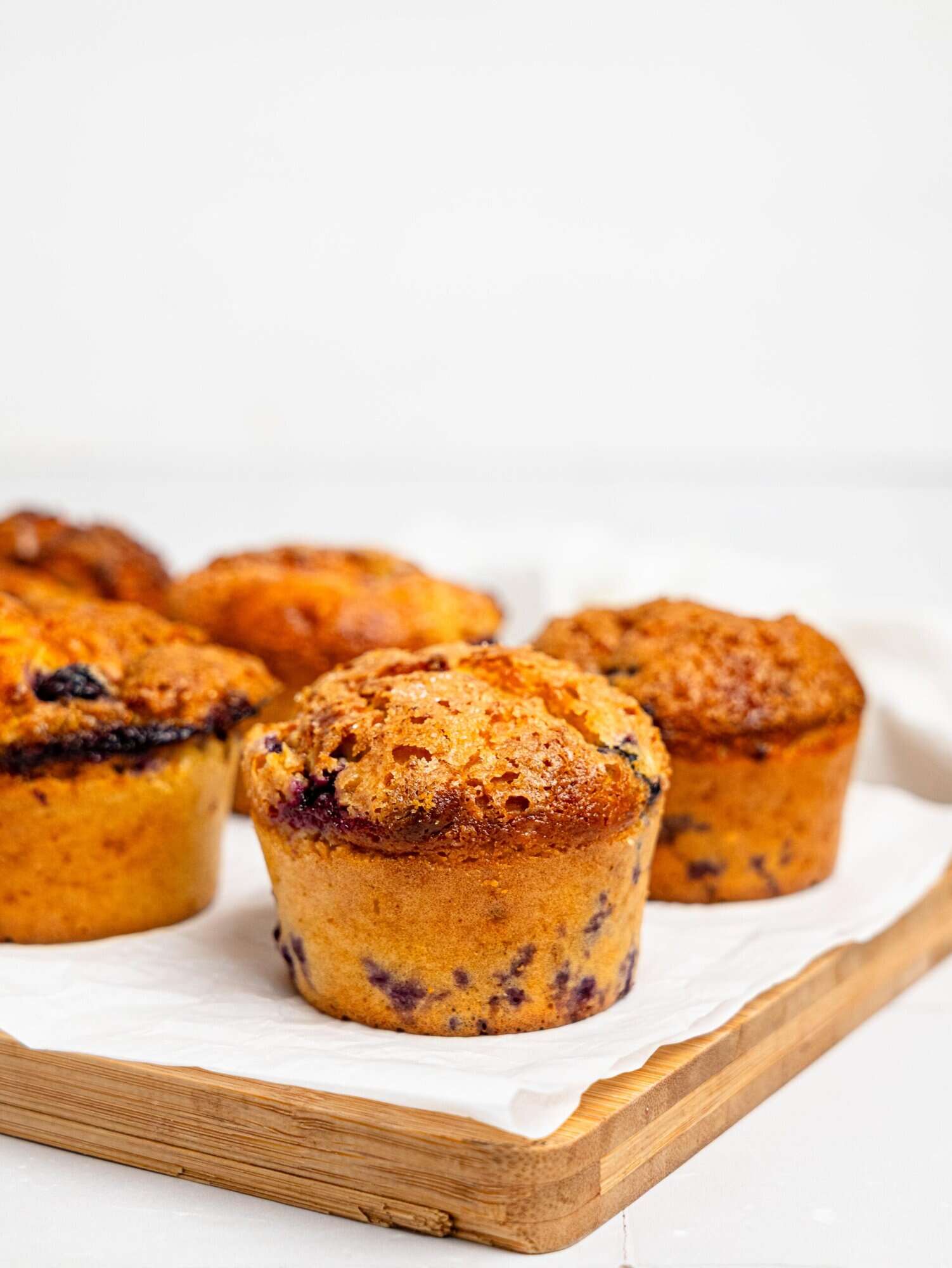 Cottage Cheese Blueberry Muffins on a wooden board.