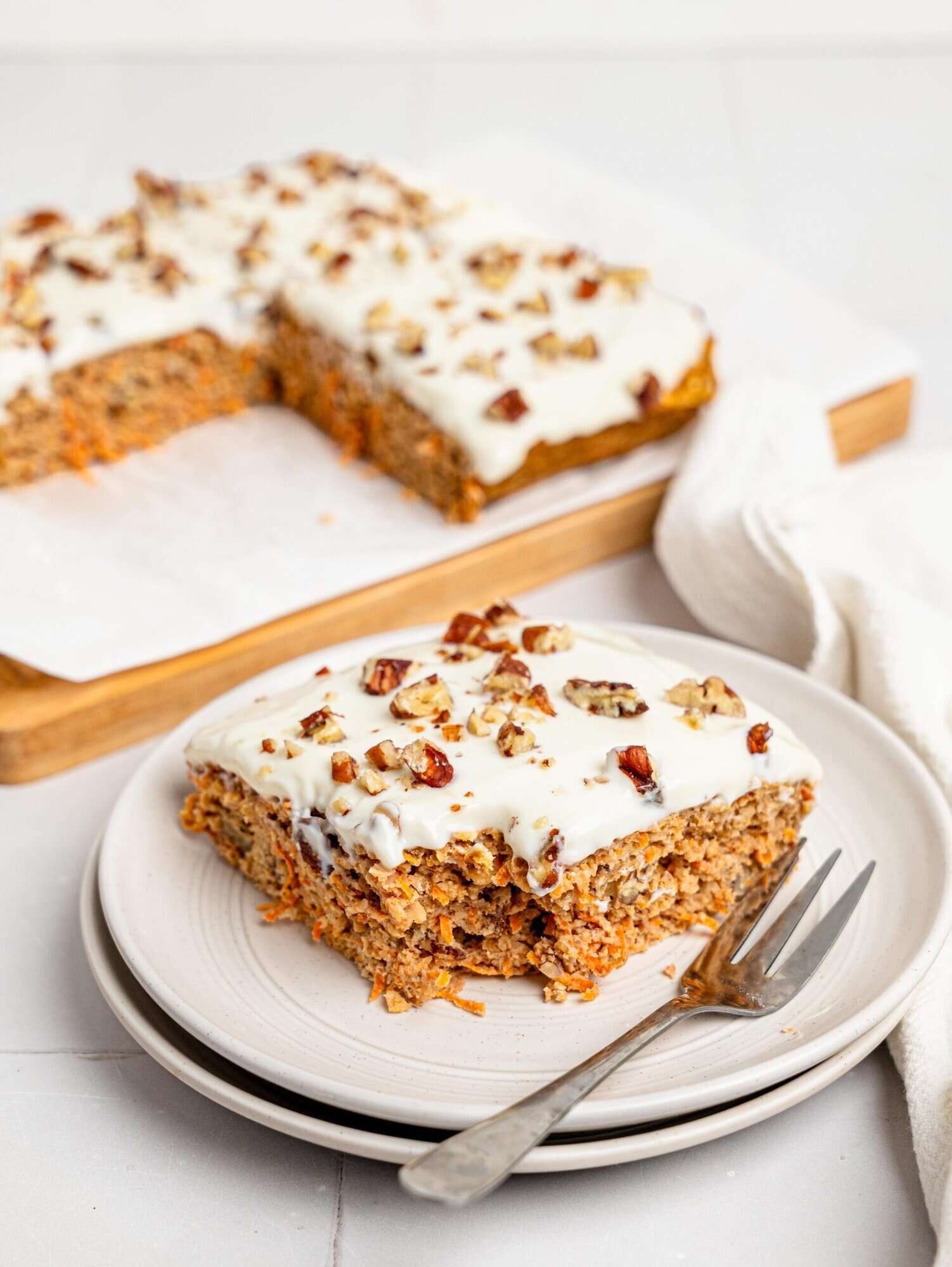 A half-eaten slice of carrot cake baked oats on a white plate.