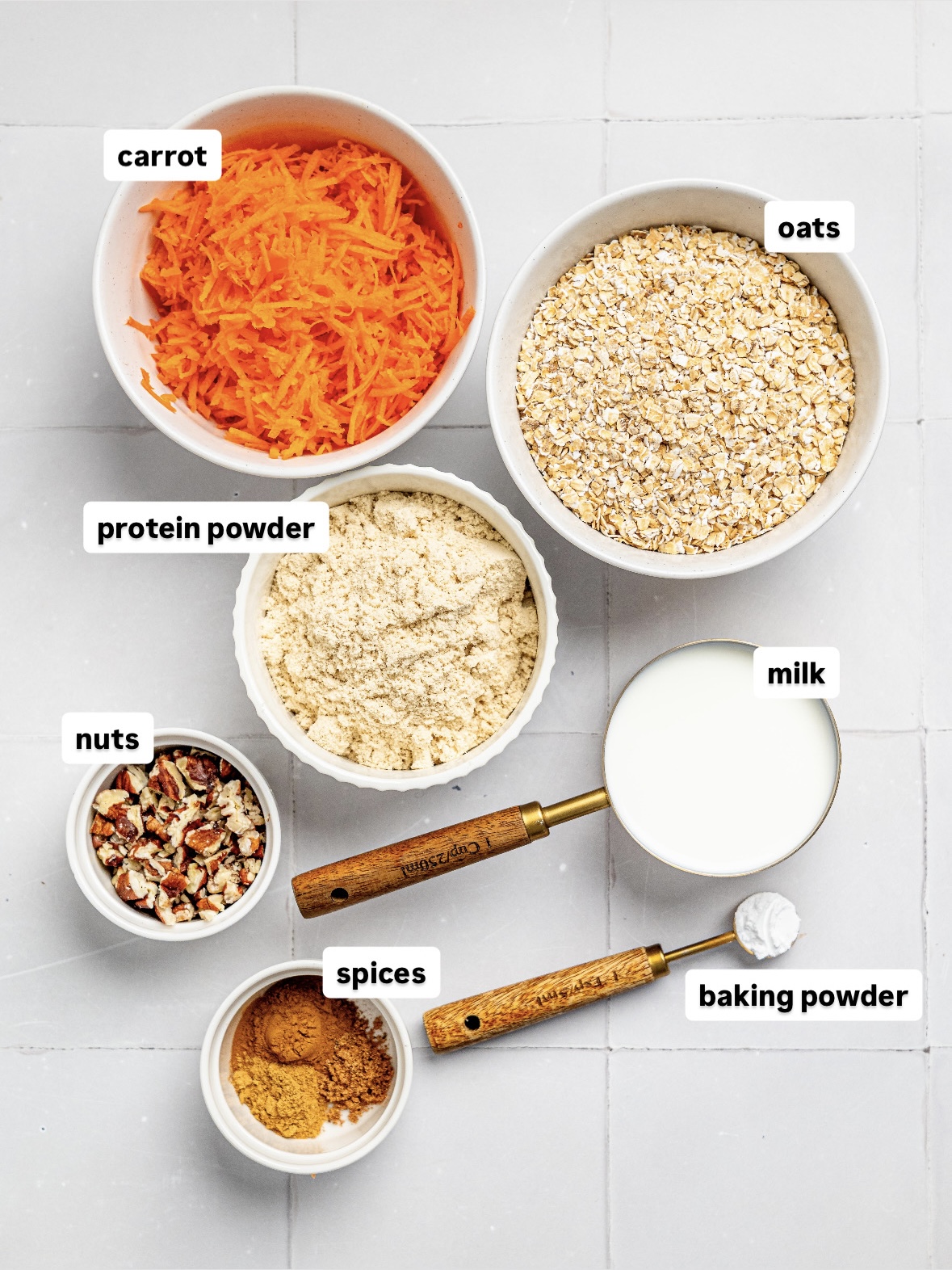 Ingredients for carrot cake baked oats on a white counter.