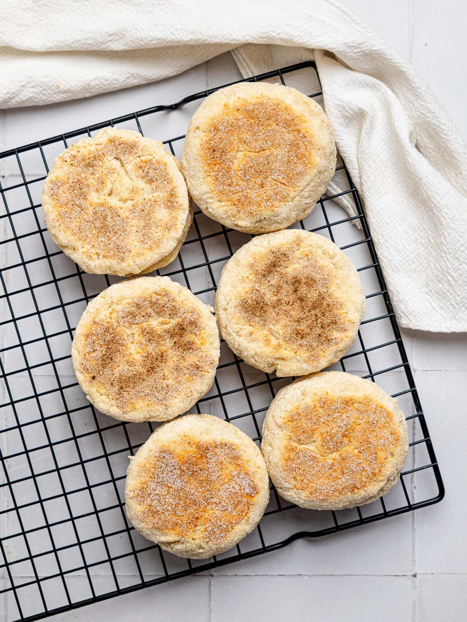 English muffins cooling on a wire rack.
