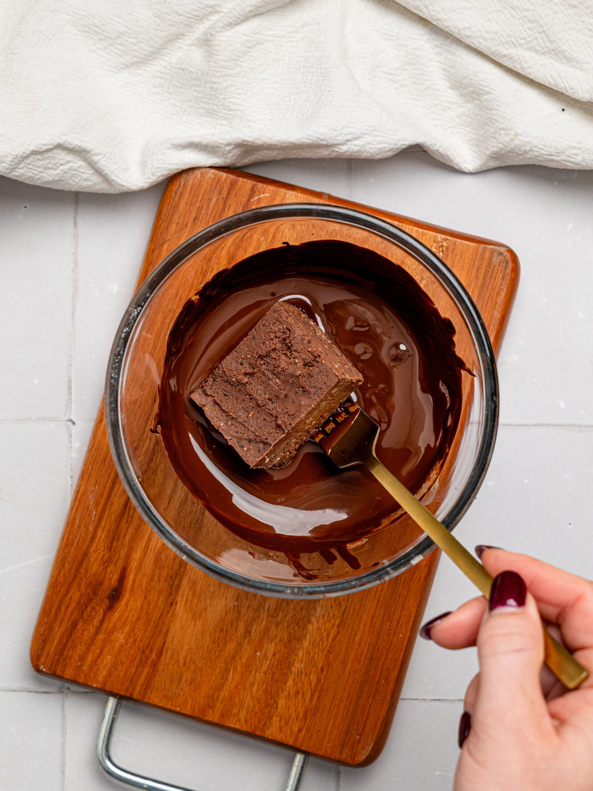 Dipping a black bean brownie in dark chocolate.