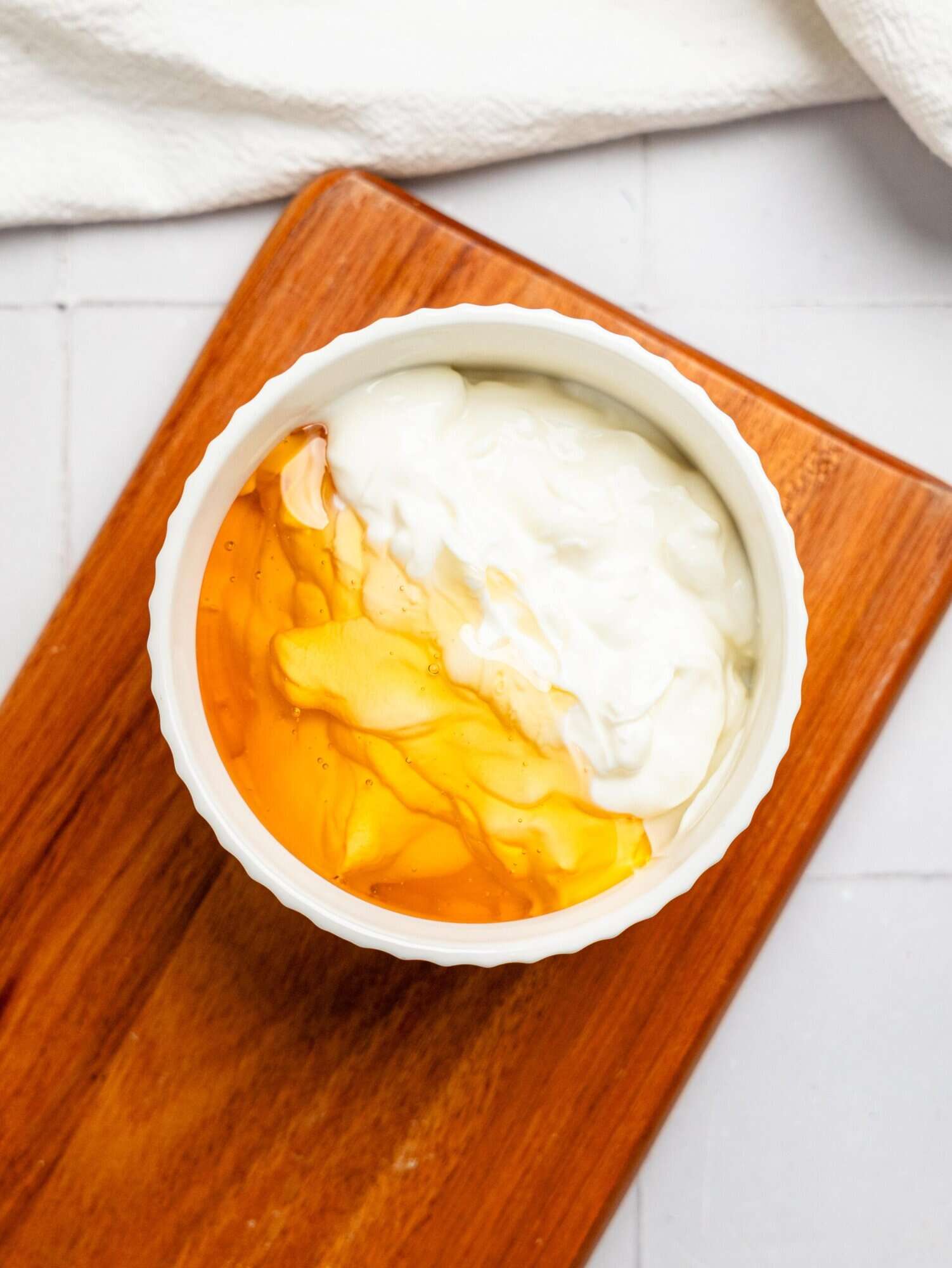 Healthy yoghurt frosting ingredients in a small white bowl.