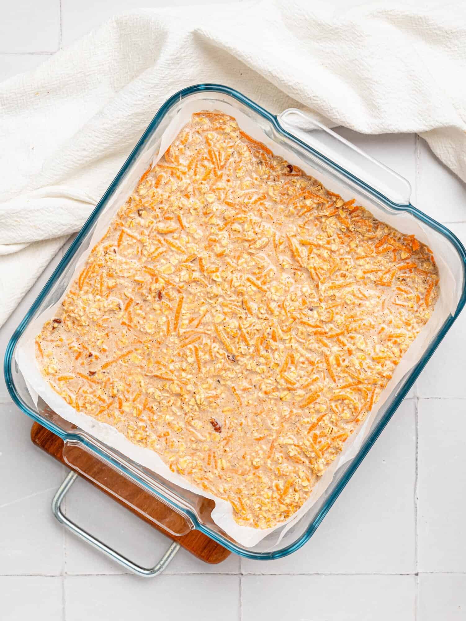 Carrot cake baked oats mixture in a glass baking dish before baking.
