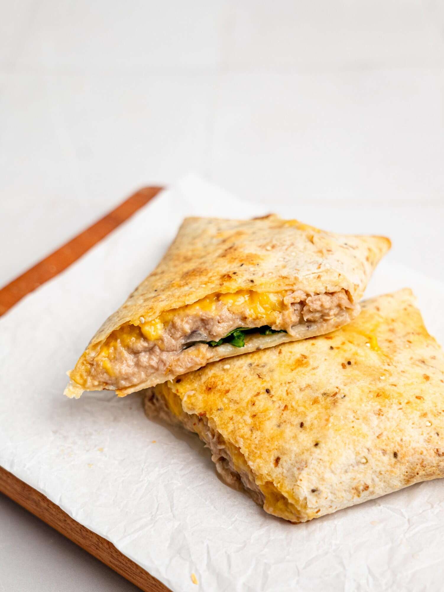 A tuna melt wrap sliced in half.