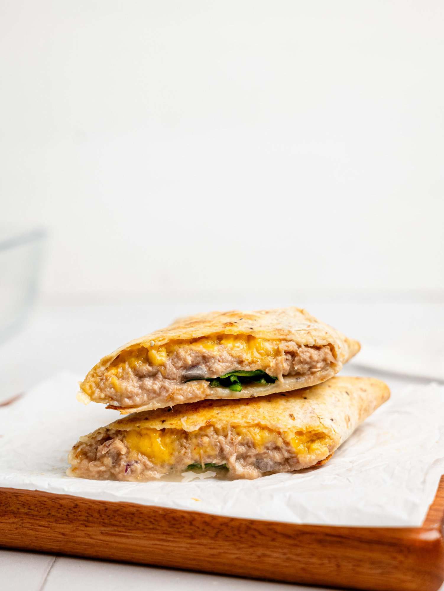 A tuna melt wrap sliced in half.