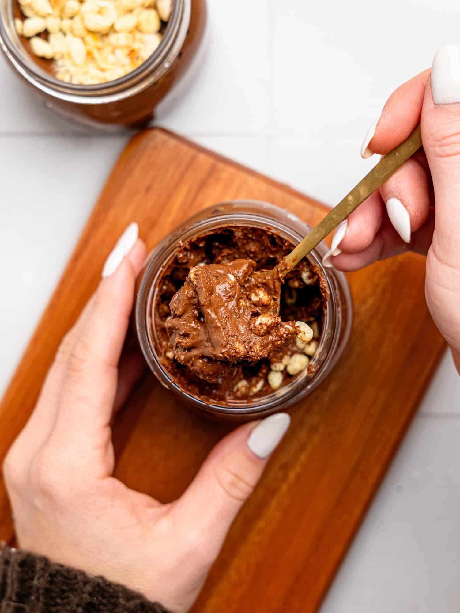 Spooning a bite of Ferrero Rocher Cottage Cheese Chocolate Pudding out of a jar.