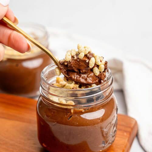 Spooning a bite of Ferrero Rocher Cottage Cheese Chocolate Pudding out of a jar.