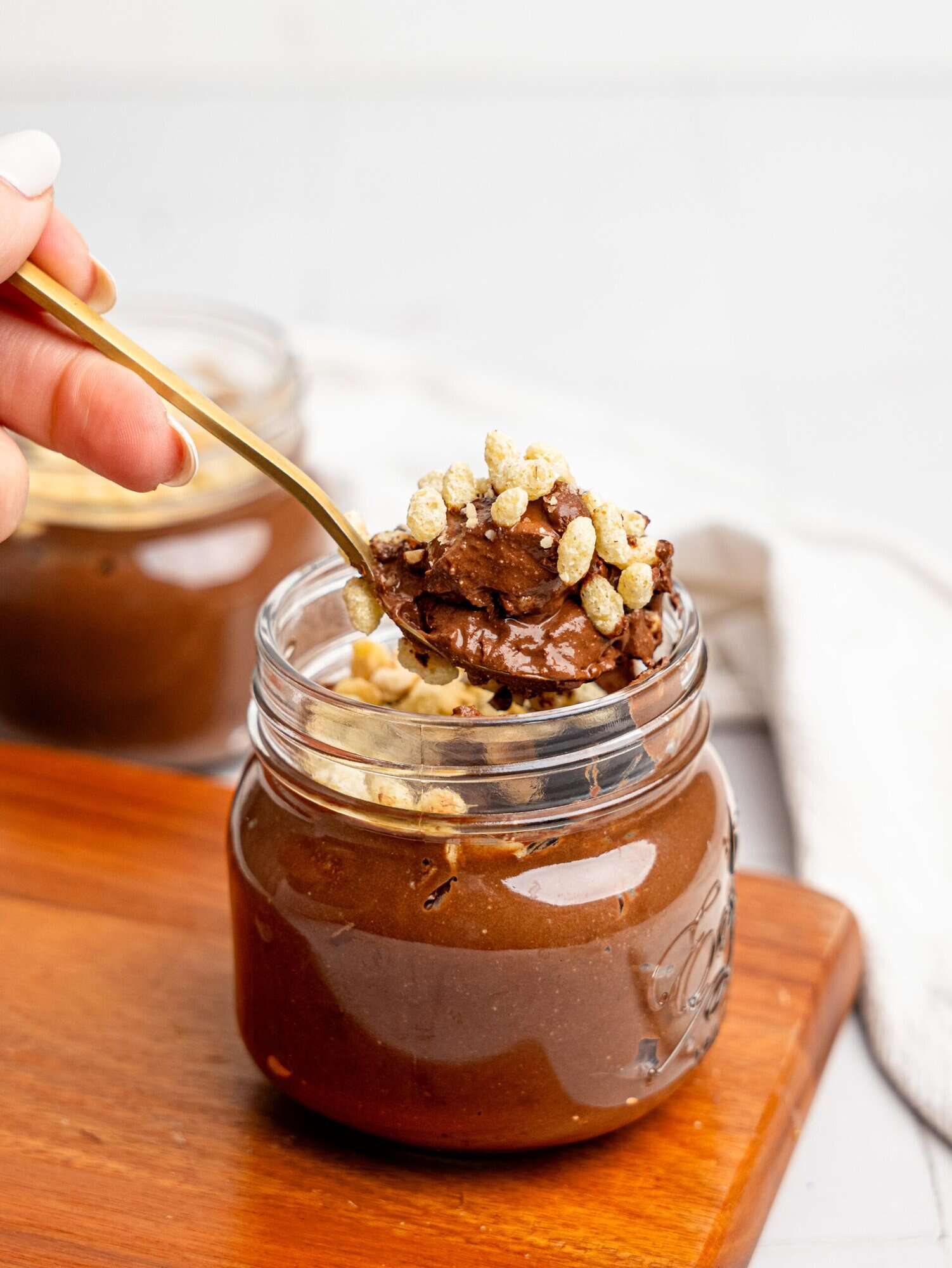 Spooning a bite of Ferrero Rocher Cottage Cheese Chocolate Pudding out of a jar.