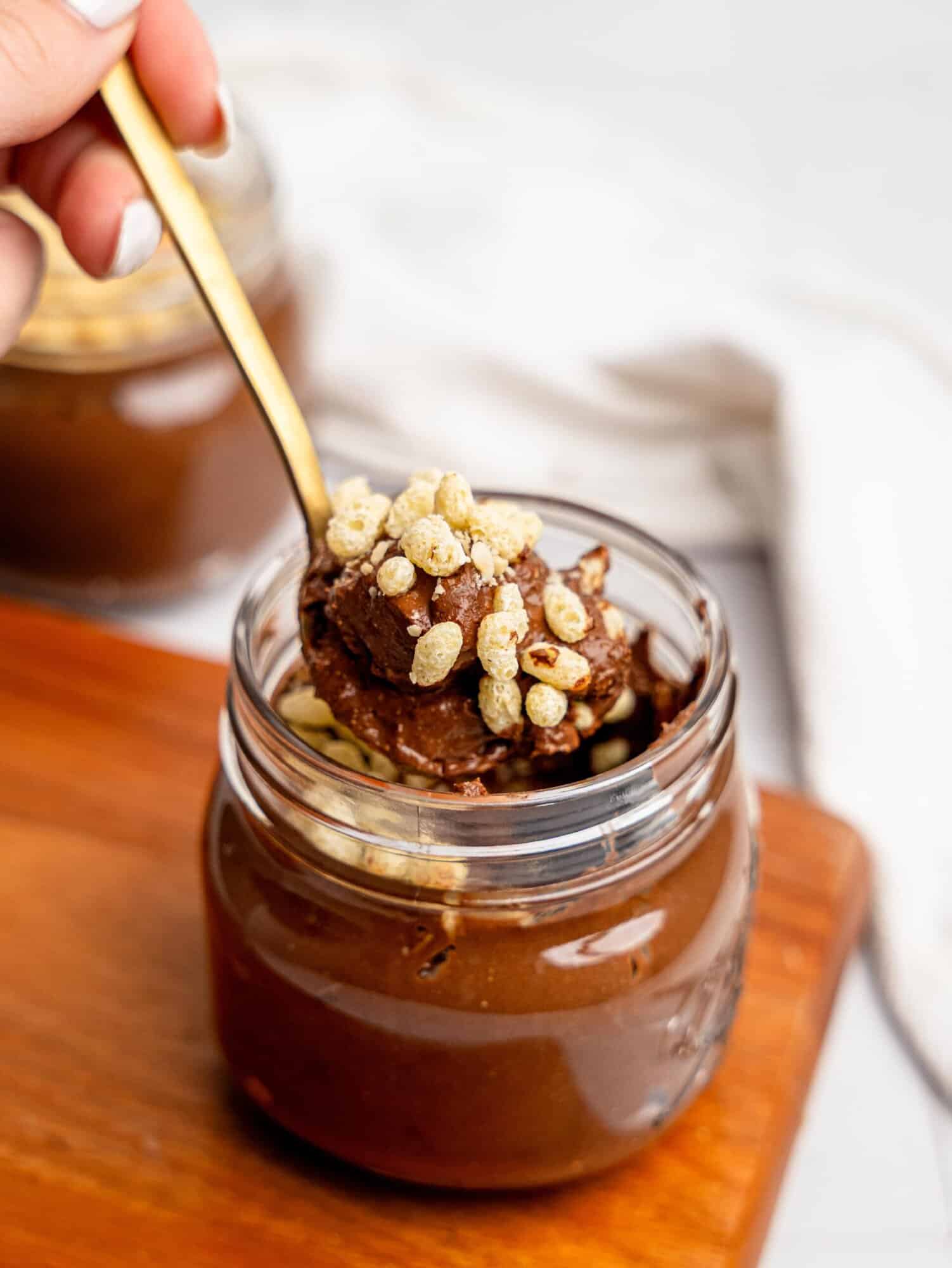 Spooning a bite of Ferrero Rocher Cottage Cheese Chocolate Pudding out of a jar.