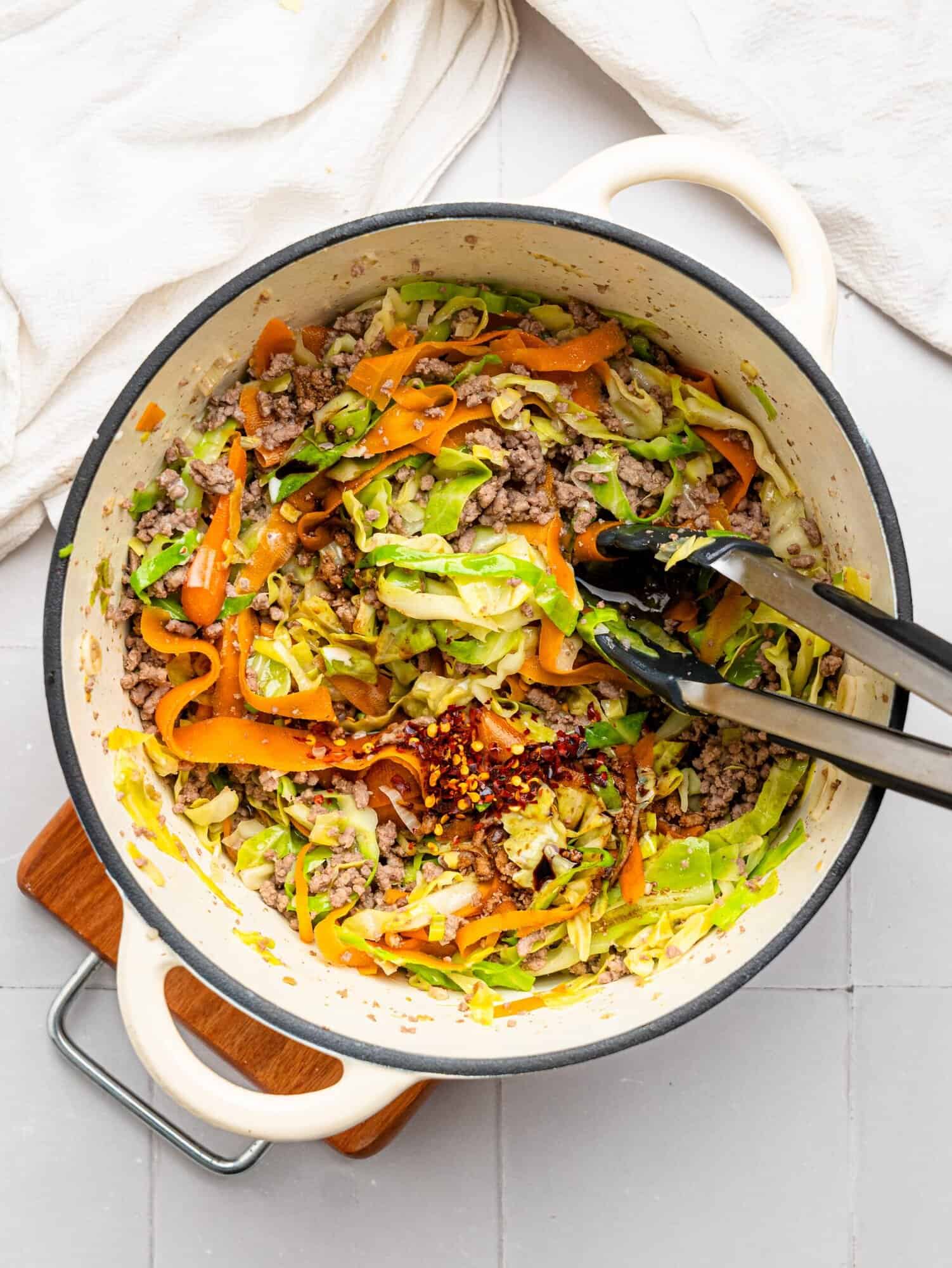 Spring roll in a bowl ingredients in a large white pot.