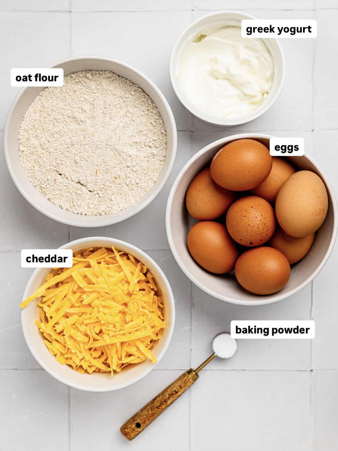 Ingredients for cheesy oat flour bread laid out on a counter.