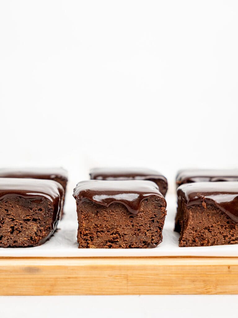 Healthy Brownies with Chocolate Ganache on a cutting board.