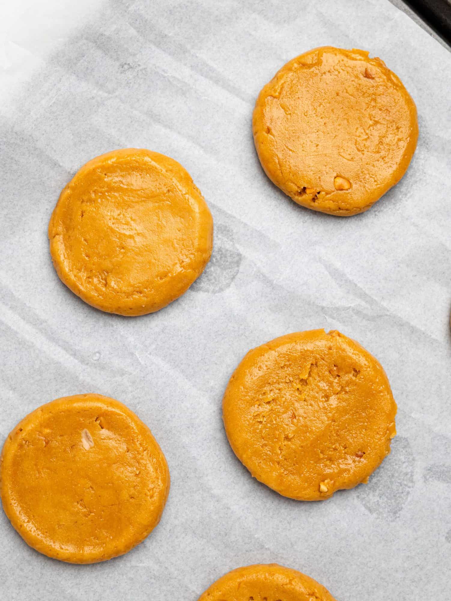Peanut butter cookies on a baking tray before baking.