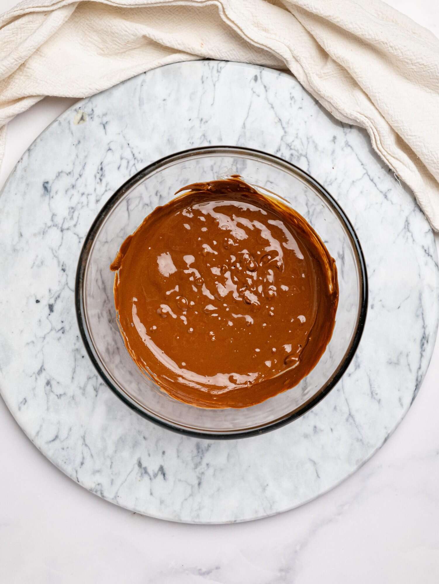 Melted dark chocolate and peanut butter in a glass bowl.