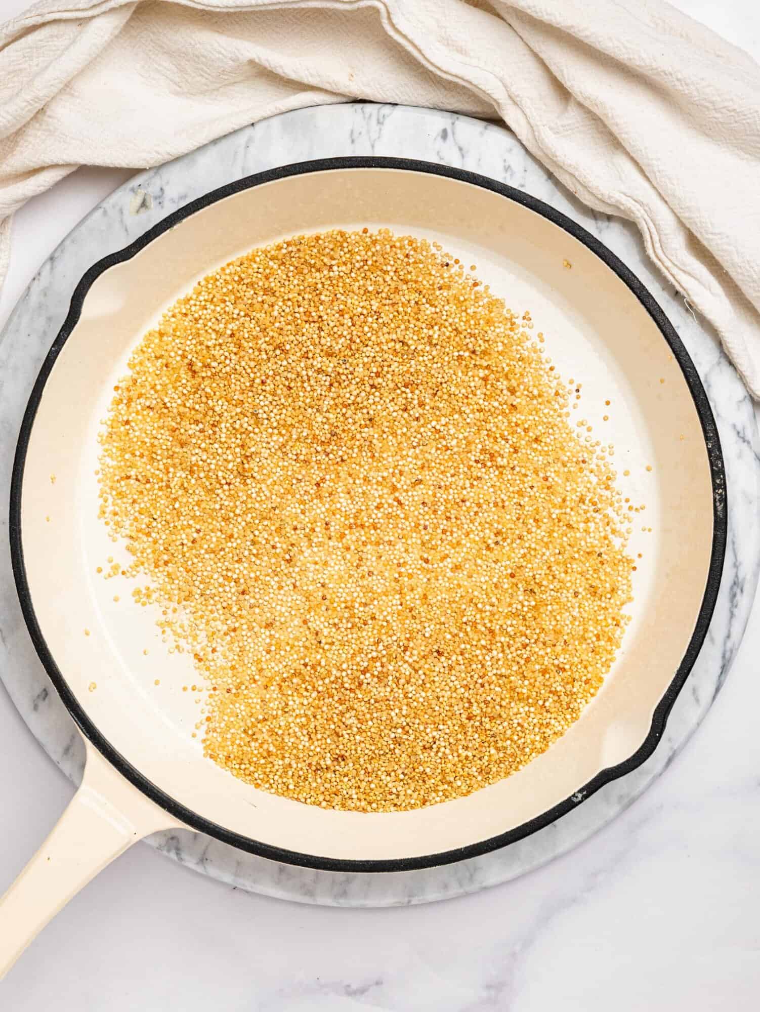 Toasted quinoa in a frying pan.