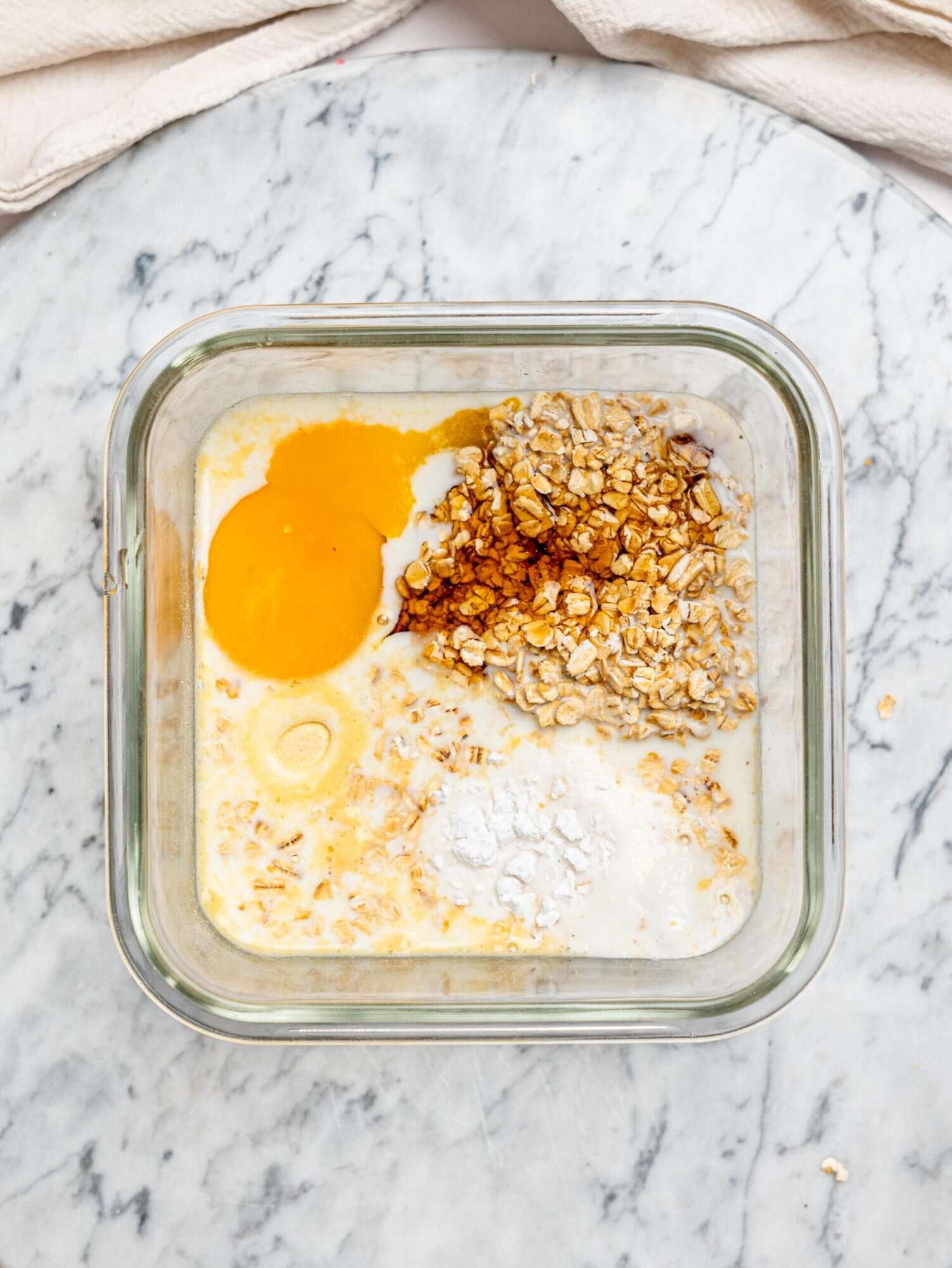 Protein baked oats ingredients in a glass meal-prep container.