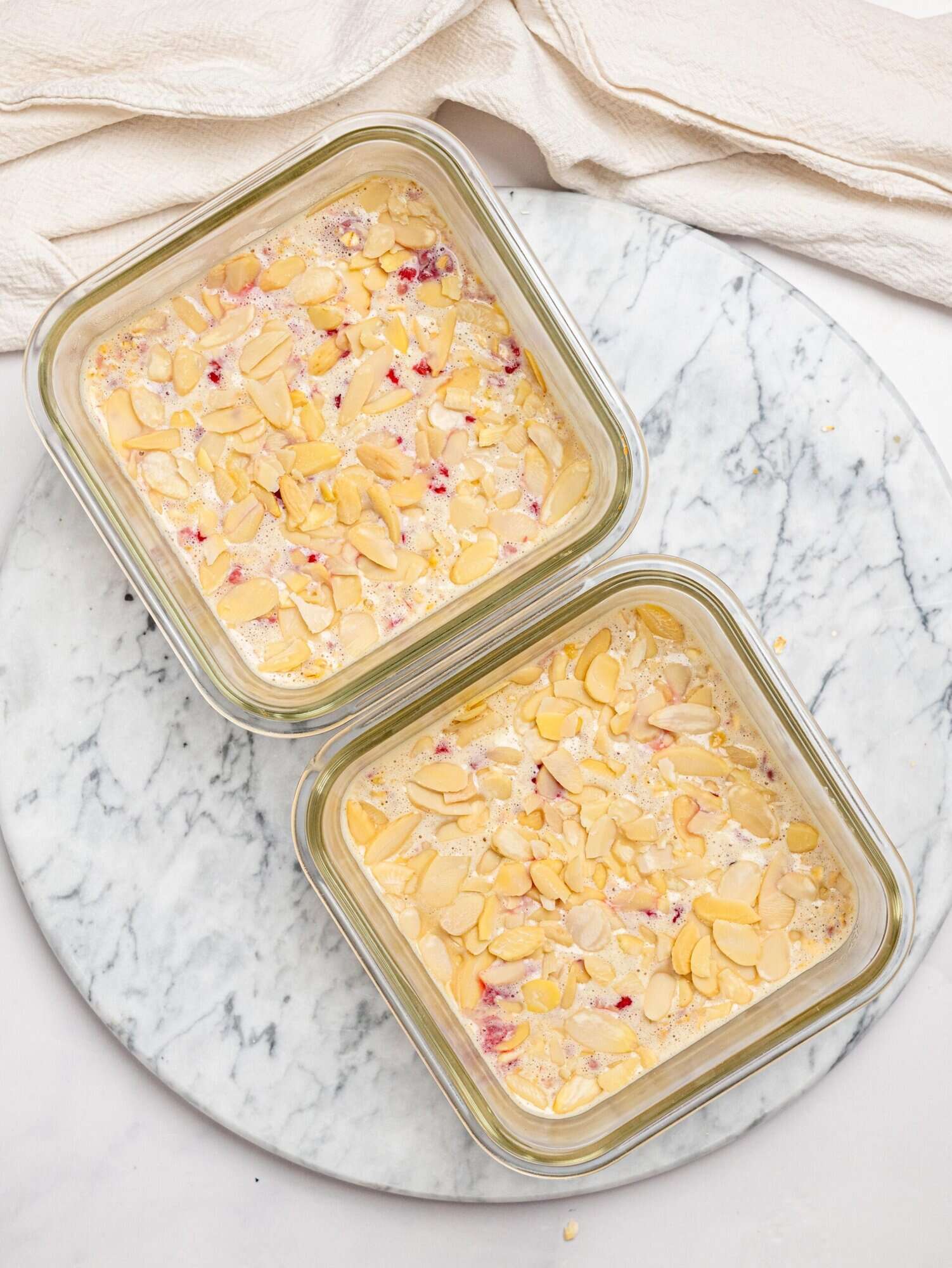 Raspberry baked oats topped with flaked almonds before baking.