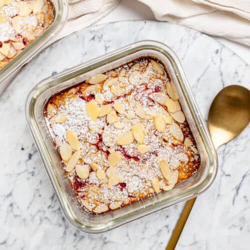 Raspberry and almond protein baked oats in a glass meal-prep container.